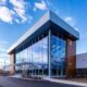 a sleek, modern pharmaceutical facility stands under a vibrant blue sky, showcasing the emblematic logo of a prominent franchise company illuminated by bright natural light, symbolizing innovation and trust in medicine.