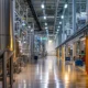 a visually striking comparison of a bustling third-party pharmaceutical manufacturing plant alongside a sleek, modern in-house production facility, showcasing the contrast between collaborative efficiency and controlled precision in vibrant, clinical lighting.