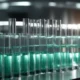a sleek, modern pharmaceutical facility glows under bright, sterile lighting, showcasing a row of pristine palmitoylethanolamide tablets in clear glass vials, emphasizing reliability and precision in medicine manufacturing.