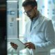 a sleek, modern office space showcases a confident business professional reviewing data and strategies on a high-tech tablet, surrounded by vibrant charts and pharmaceutical products, embodying the ambition and clarity needed for success in the pcd pharma franchise industry.