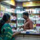 Pharmacist assisting customers in a modern pharmacy in Odisha, showcasing a variety of pharmaceutical products